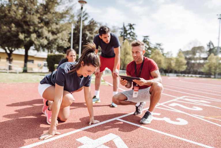 Track coach talking to runners